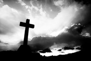 cross detail in silhouette and the clouds in the sky